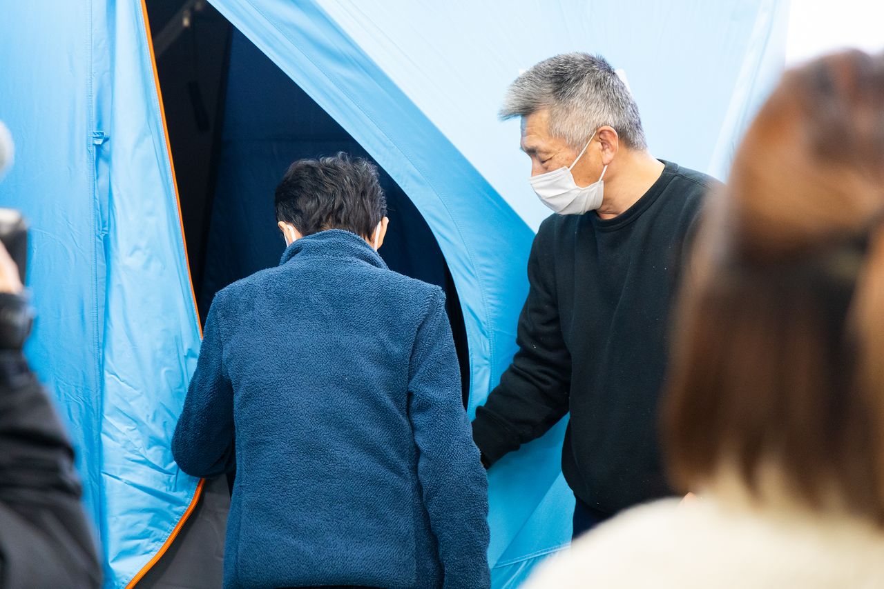 利用者の女性に、使用方法を説明する管理担当者