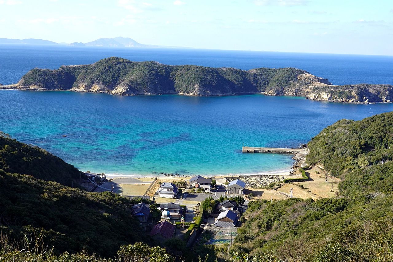 島北部の入り江に面した頭ヶ島集落。天主堂は集落の奥、緩やかに傾斜する山裾に立つ。石は正面に浮かぶ小島から切り出した 写真=天野久樹