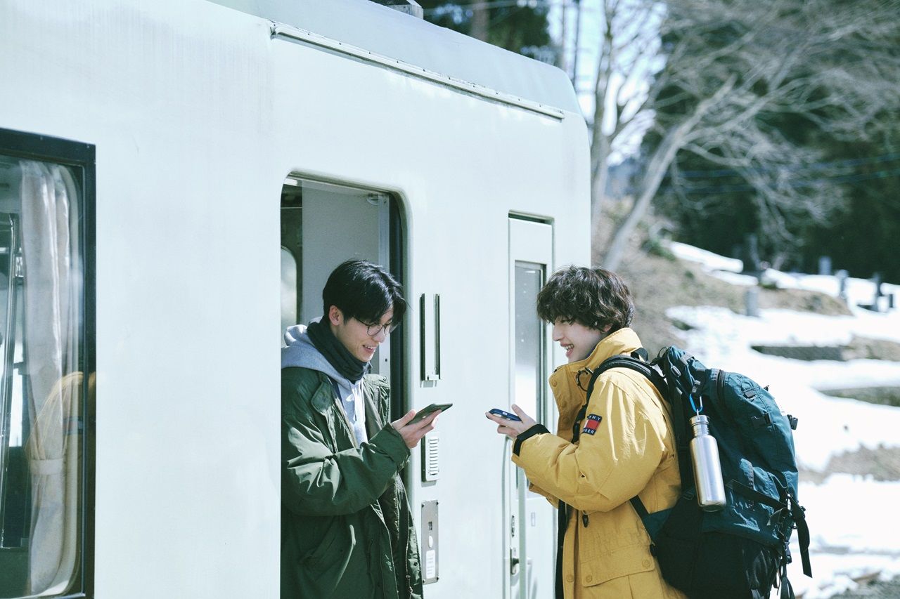 Jimmy et Koji (Shunsuke Michieda, à droite) se rencontrent dans le train. Le réalisateur Michito Fujii déclare : « Ce fut une expérience de tournage dramatique en raison des contraintes. » ©2024 « Seishun 18×2 » Film Partners