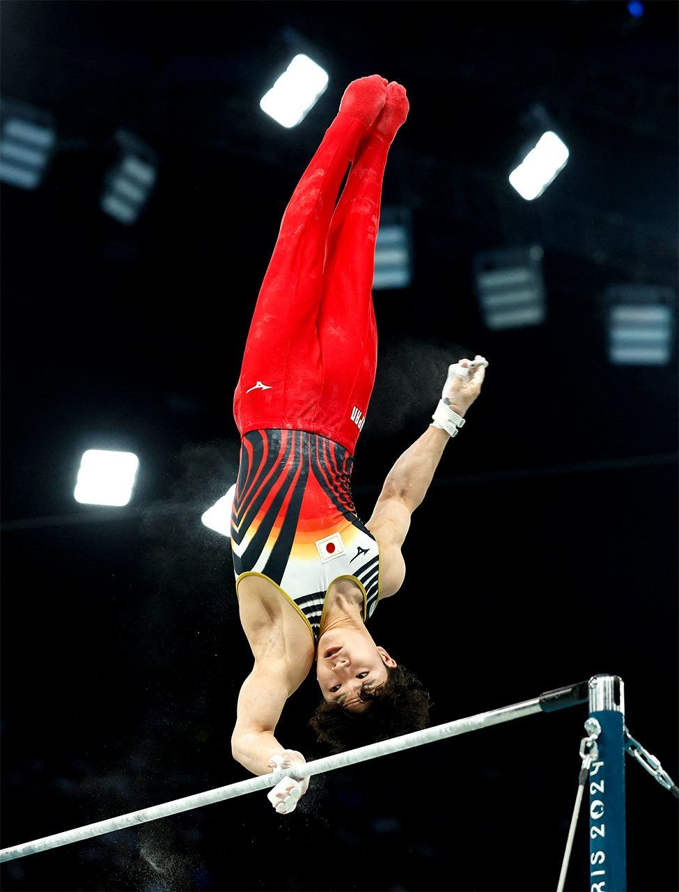 体操男子:個人総合で鉄棒の演技をする岡慎之助。この種目のほか団体総合と鉄棒でも金メダル、平行棒では銅メダルを獲得した=2024年7月31日、フランス・パリ(ロイター)