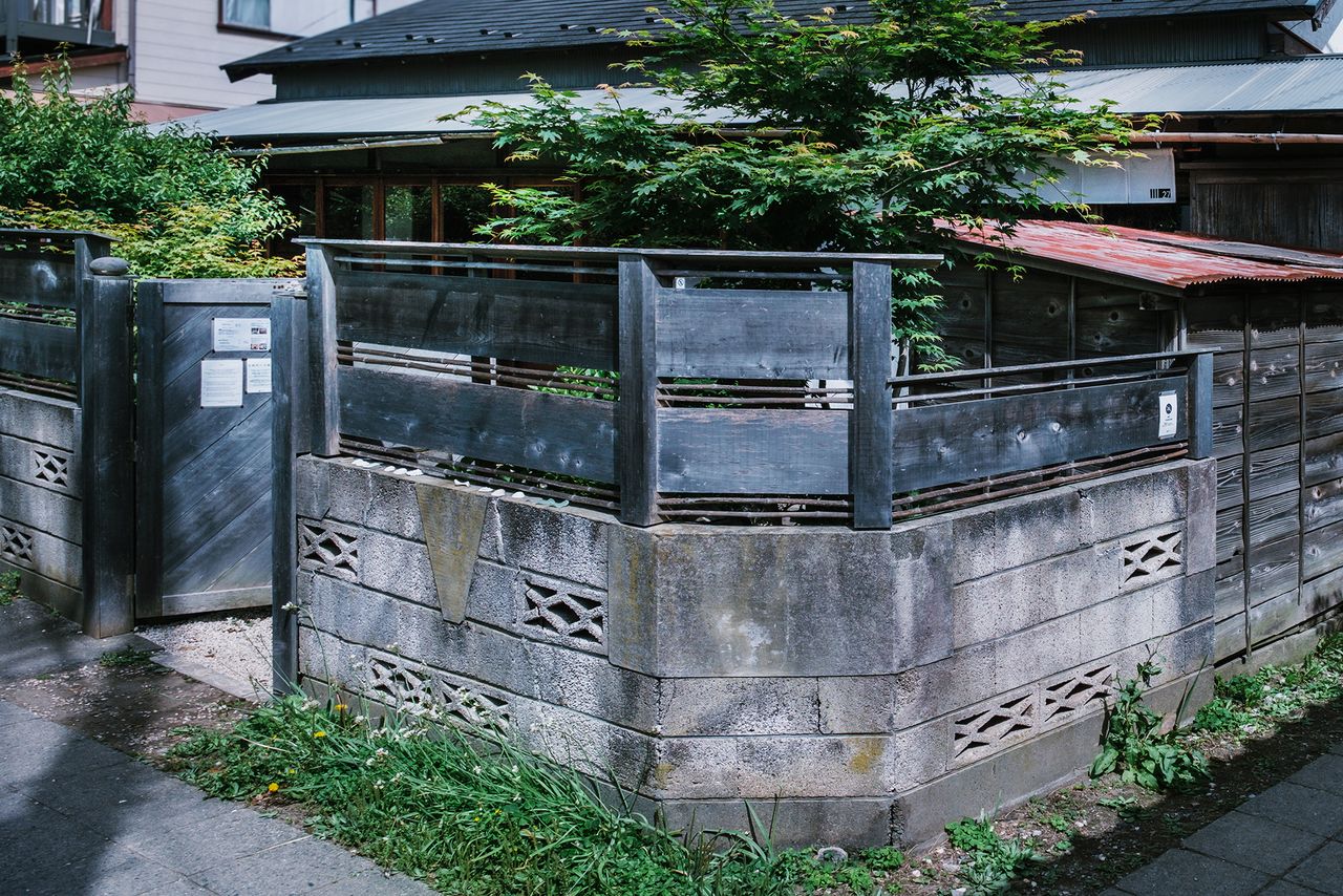 ブロック塀に板塀を組み合わせた外観が古い街並みになじむ