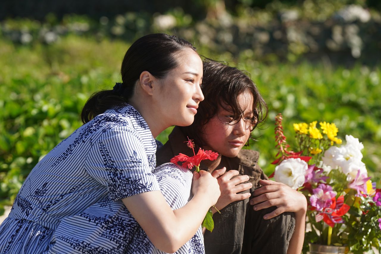 ヤマコは米兵相手のバーで働きながら勉強し、教師になってオンとの約束を果たす