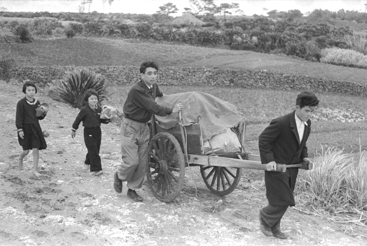 沖永良部島で荷車を押す日出男氏(中央)