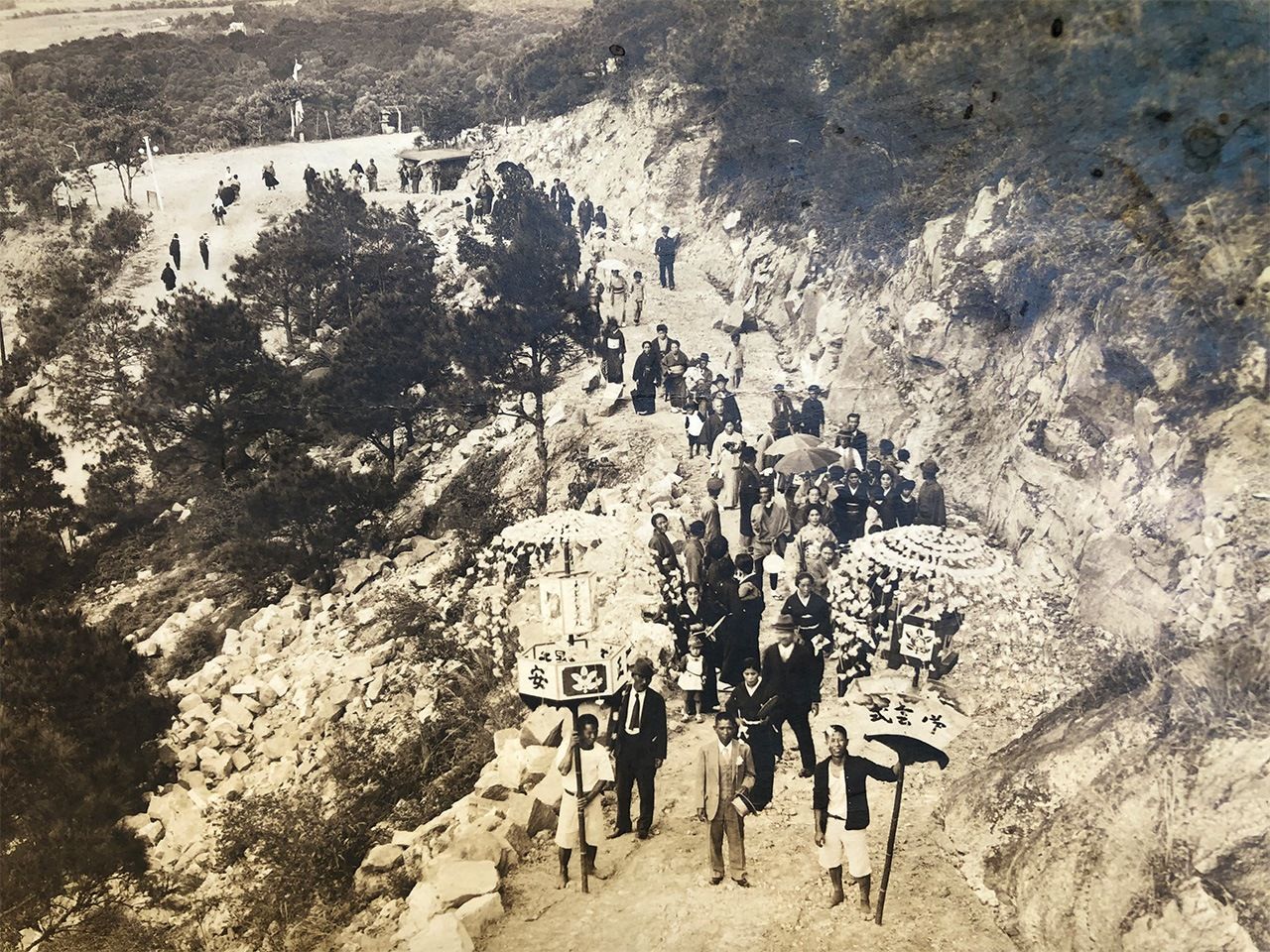 地熱谷裏山の道路を独力で拓き、開通式で先頭を歩く庄太郎。