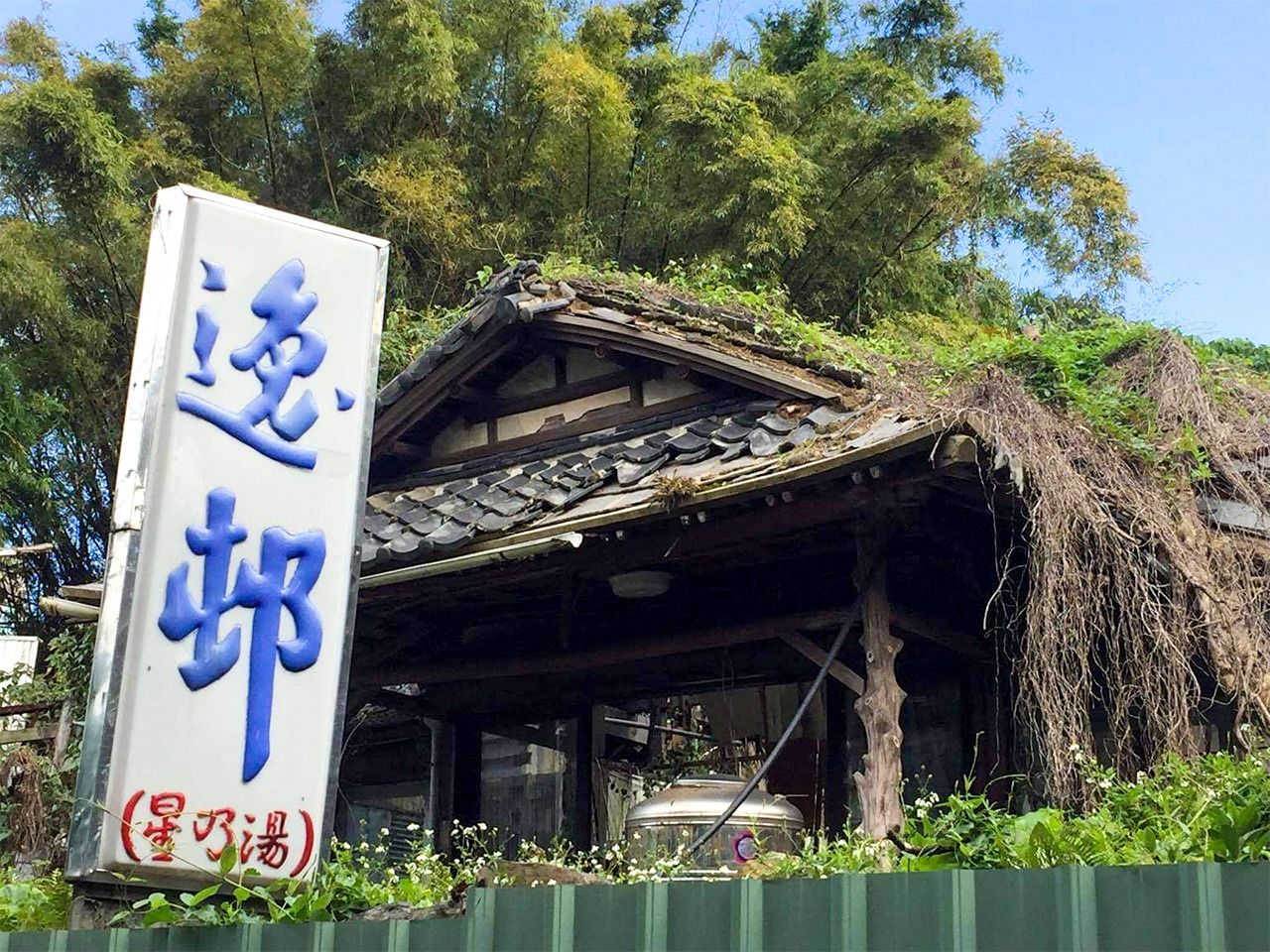 2013年に閉館した「逸邨大飯店」はすっかり荒れ果てている。瓦屋根と看板が残り、「星乃湯」の名も・・・。(撮影・広橋賢蔵)