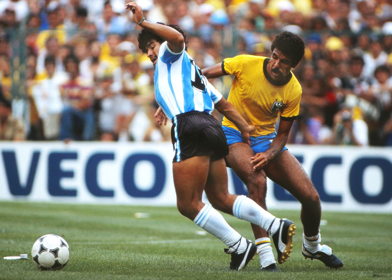 1982年ワールドカップ・スペイン大会のブラジル戦。当時のサッカー少年がこぞってマネをした「マラドーナ結び」。通常より⻑いひもを⾜⾸に巻きつけて結ぶが、効果のほどは今ひとつ不明だった　写真：Colorsport/アフロ