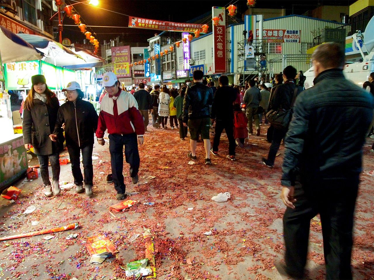 爆竹の燃えかすを踏みしめて進む媽祖の信徒たち(筆者提供)