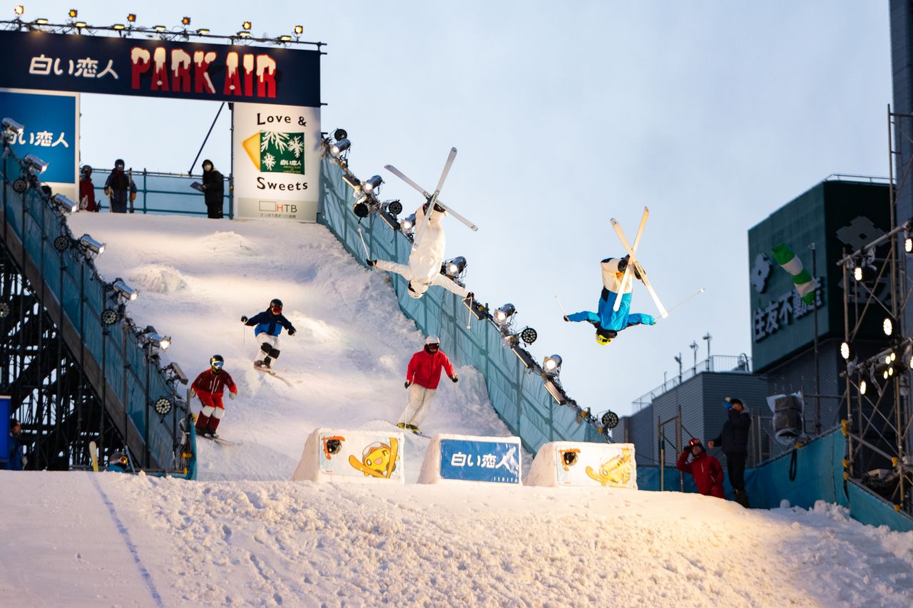 高さ24メートル、全長60メートルの巨大ジャンプ台がビルを背景に出現。スキーヤーやスノーボーダーが華麗な技を披露する　©HTB
