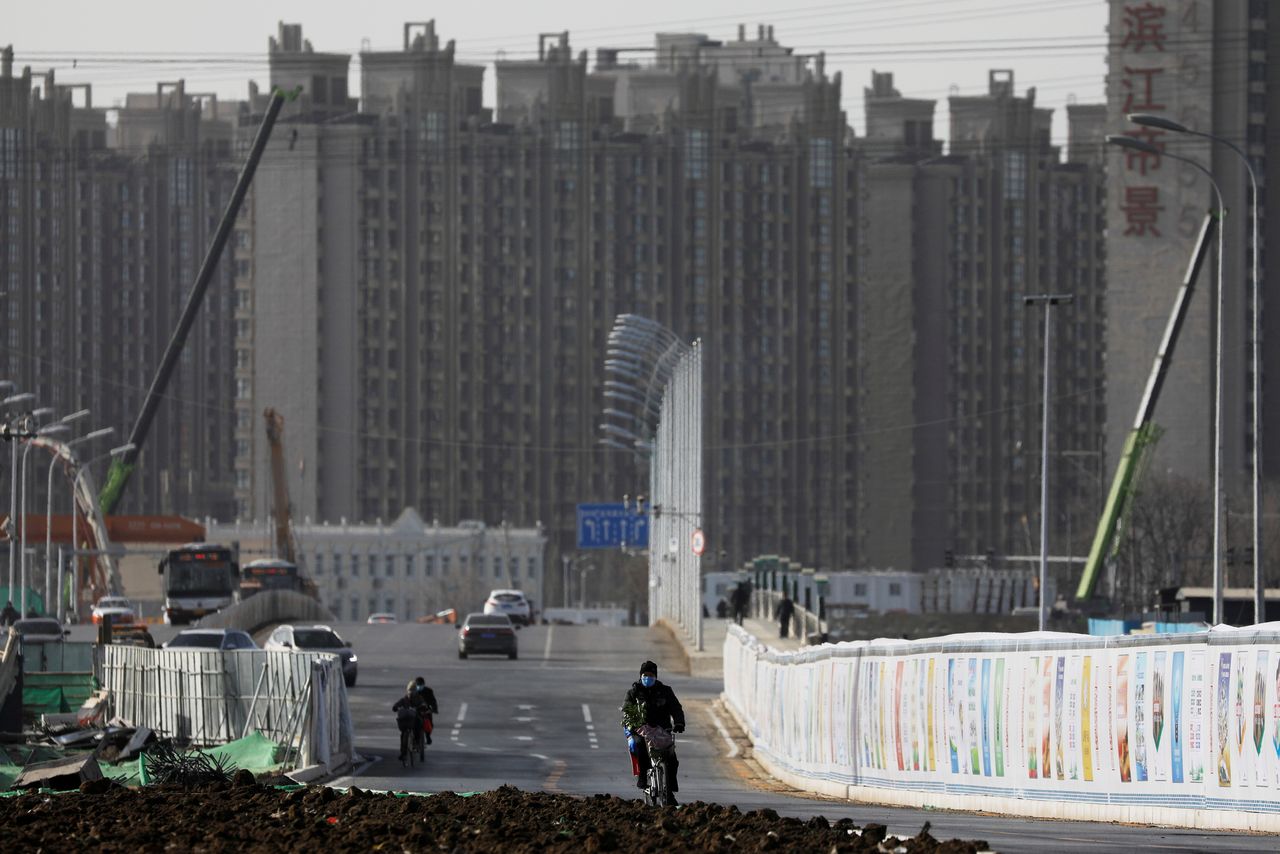 １０月１９日、中国で不動産税（日本の固定資産税に相当）導入の動きが勢いを増そうとしている。写真は北京の住宅街付近を自転車で通行する男性。１月１３日撮影（２０２１年　ロイター/Tingshu Wang）