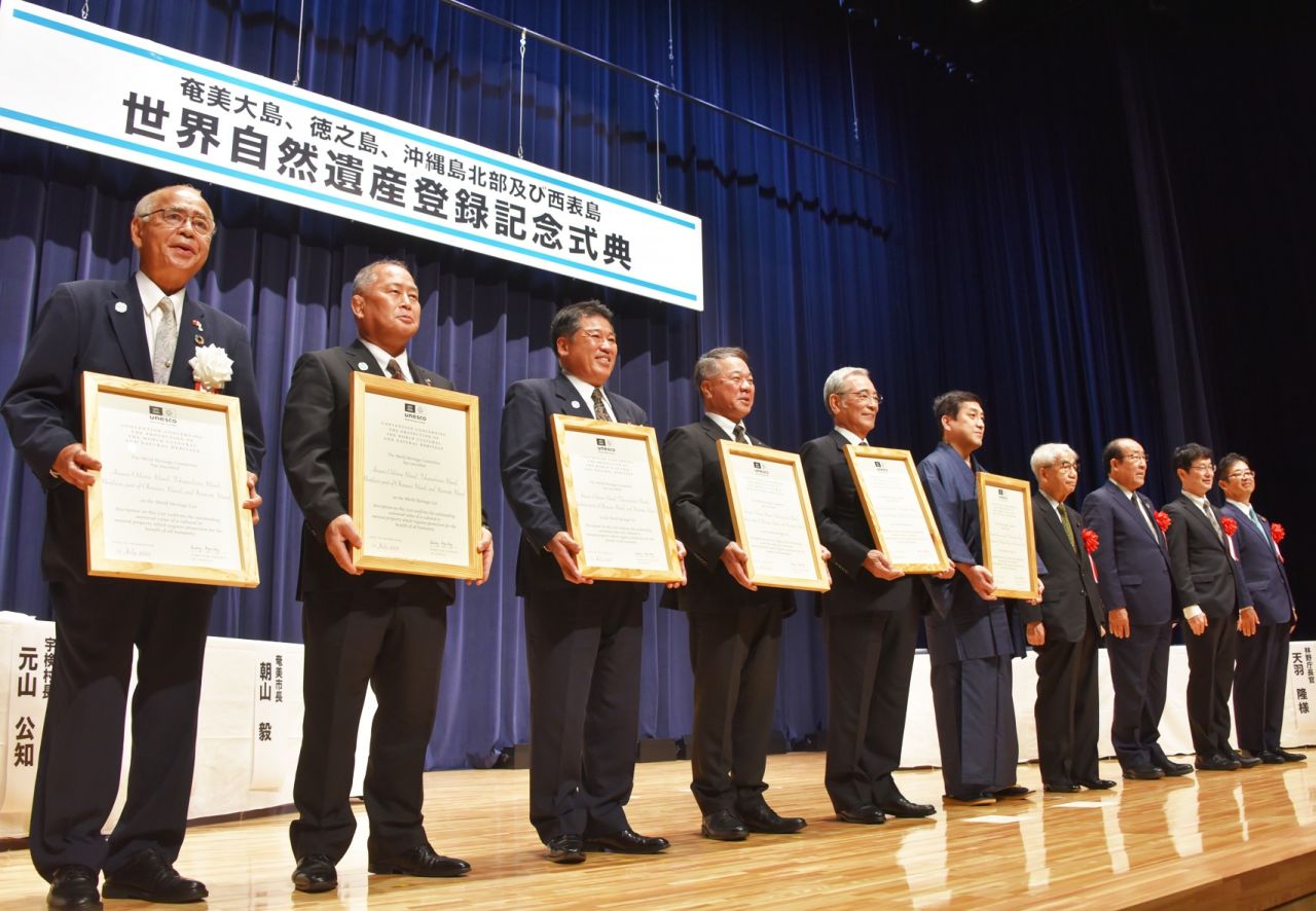 世界遺産認定証のレプリカを授与された塩田知事（右から５人目）と奄美大島５市町村長ら＝２３日、奄美市名瀬