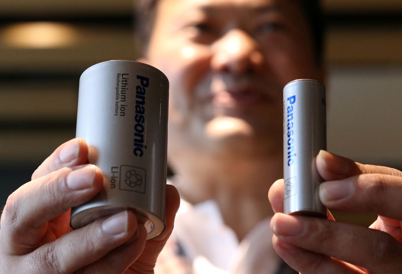 ２６日の東京株式市場でパナソニック株は大幅に３日続伸し、年初来高値（１５２０円＝２月１５日）を更新した。写真はテスラ向け電池のプロトタイプを持つパナソニックエナジーの只信一生社長。１０月２５日、東京で撮影（２０２１年　ロイター/Tim Kelly）