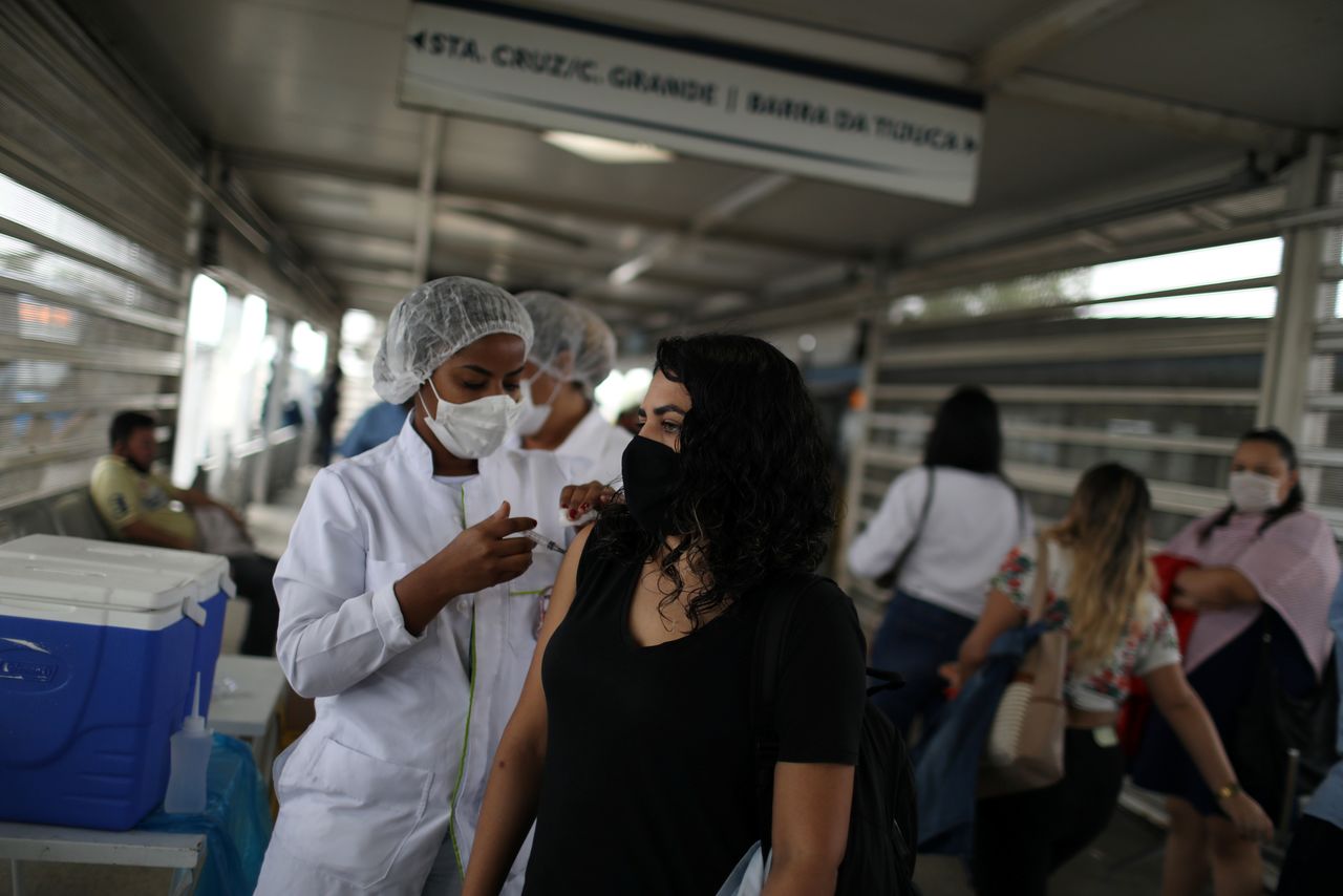 ロイターの集計によると、新型コロナウイルスの感染者は世界全体で２億４５４８万人を超え、死者は５２１万０１００​人となった。写真はリオデジャネイロでワクチン接種を受ける人。２７日撮影（２０２１年　ロイター／Pilar Olivares）