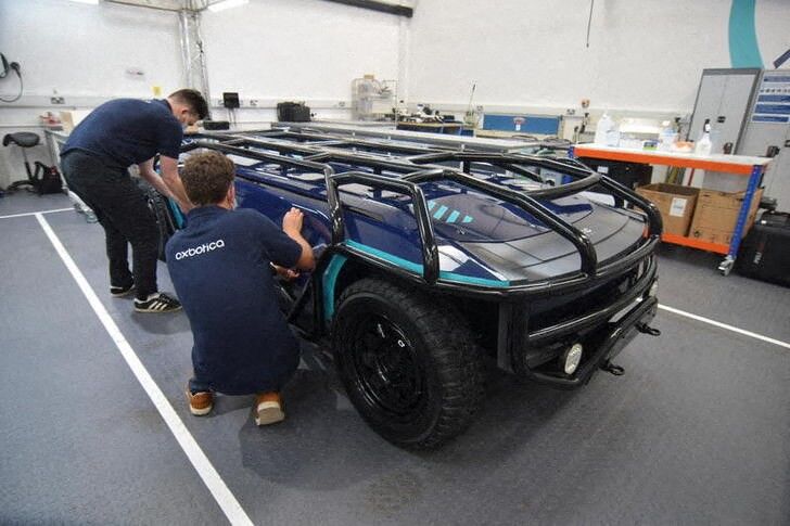 完全な自動運転による乗用車はスタートを切るにも苦労しており、投資家の中には、ドライバー抜きのトラックの方が最初にゴールにたどり着く方に賭けようという動きも見られる。写真は10月、アプライドEVが開発した用途特化型の完全電動による自動運転車を使って作業する、オクスボティカの従業員。英オックスフォードで撮影(2021年 ロイター/Nick Carey)