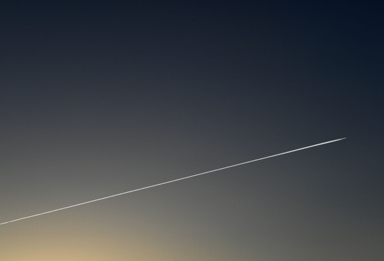 3月2日、ANAホールディングス傘下の全日本空輸(ANA)の平子裕志社長は、緊迫化するウクライナ情勢を受け、「安全運航の担保が大前提」とした上で、安全が担保できない場合はロシア上空を通らないルートの飛行が選択肢になるとの考えを示した。写真はベルリン上空の飛行機雲。2020年4月撮影(2022年 ロイター/Annegret Hilse)