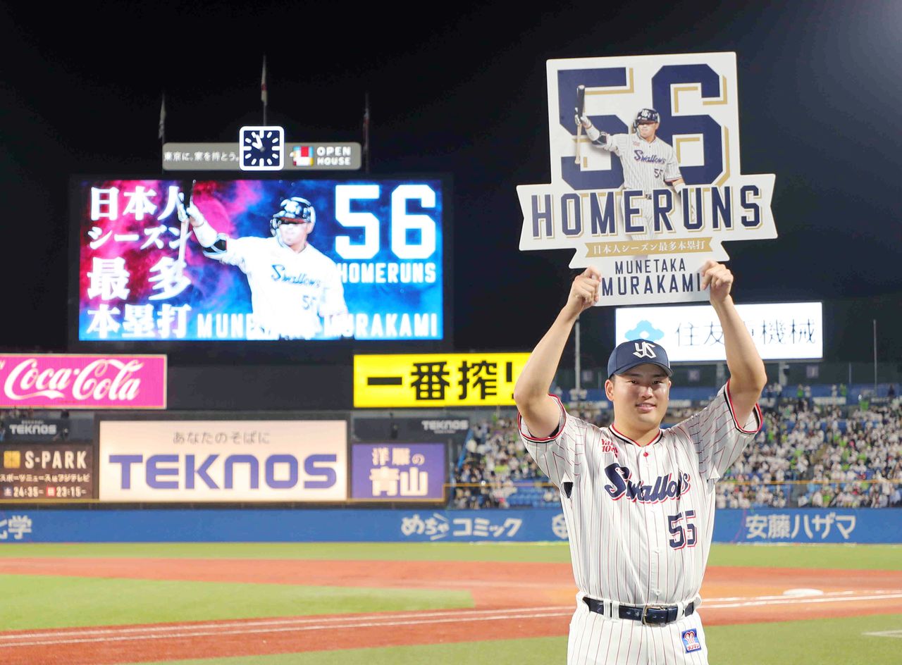 56号となるソロ本塁打を放ち、記念のボードを掲げるヤクルトの村上宗隆(中央)=2022年10月3日、東京・神宮球場(時事)