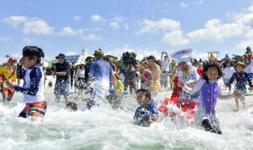 和歌山県白浜町の白良浜で海へ飛び込む海水浴客ら＝3日午前