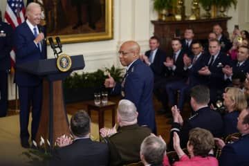 米ホワイトハウスのイベントで、バイデン大統領（左端）の前で笑顔を見せるチャールズ・ブラウン空軍参謀総長（中央）＝4月28日（AP＝共同）