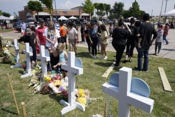 銃乱射があった米南部テキサス州アレンのショッピングモール近くで犠牲者を追悼する人たち＝8日（AP＝共同）