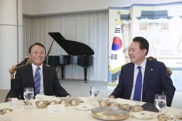 韓国の尹錫悦大統領（右）と夕食を共にする自民党の麻生副総裁＝11日、ソウル（大統領府提供・共同）