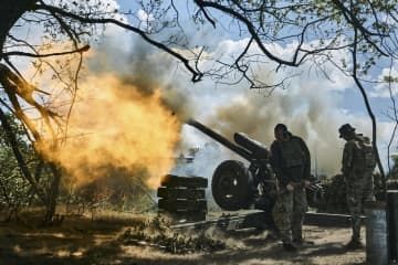 ウクライナ東部ドネツク州バフムト付近で、砲を発射するウクライナ兵＝12日（AP＝共同）
