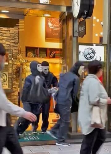 8日、強盗事件があった東京・銀座のロレックス専門店から逃走する仮面姿の3人（目撃者提供）
