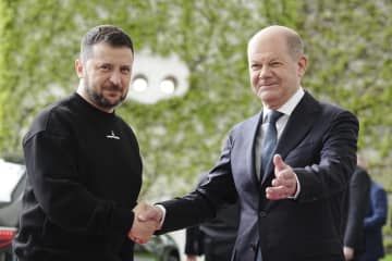14日、ドイツ・ベルリンでショルツ首相（右）の出迎えを受けるウクライナのゼレンスキー大統領（DPA提供・AP＝共同）