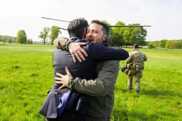 ウクライナのゼレンスキー大統領（右）と抱き合うスナク英首相＝15日、ロンドン郊外（スナク氏提供、ロイター＝共同）