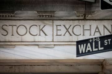 ニューヨーク証券取引所と、証券街「ウォールストリート」の標識（ロイター＝共同）