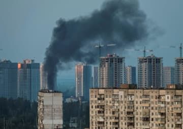18日、ウクライナ首都キーウで、ロシアのミサイル攻撃後に上がる煙（ロイター＝共同）