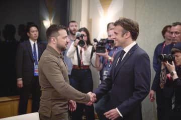 握手するフランスのマクロン大統領（右）とウクライナのゼレンスキー大統領＝20日午後、広島市（ウクライナ大統領府提供）