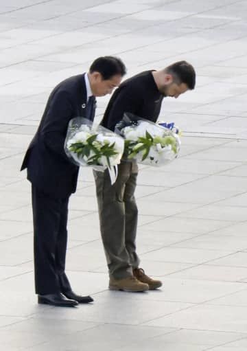 原爆慰霊碑への献花を前に、一礼する岸田首相（左）とウクライナのゼレンスキー大統領＝21日午後、広島市の平和記念公園