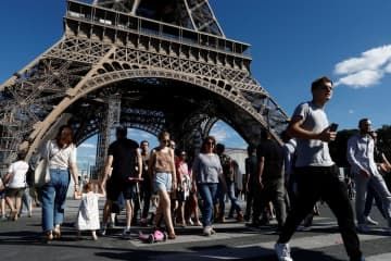 エッフェル塔の前を歩く観光客ら＝2022年7月、パリ（ロイター＝共同）