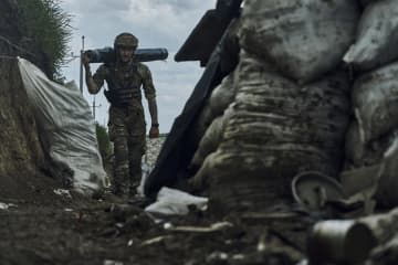 ウクライナ東部ドネツク州バフムトの前線で物資を運ぶウクライナ兵＝22日（AP＝共同）