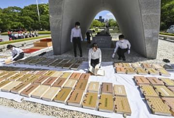 原爆慰霊碑前で行われた、原爆死没者名簿の「風通し」＝24日午前、広島市の平和記念公園