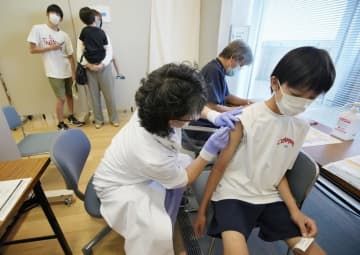 新型コロナウイルスワクチンの接種を受ける男子生徒＝2021年
