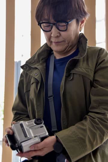 返還された長井健司さんのカメラを手にする妹の小川典子さん＝25日午後、警視庁中野署