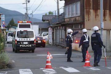 事件があった現場付近を規制する警察官＝25日午後6時55分、長野県中野市
