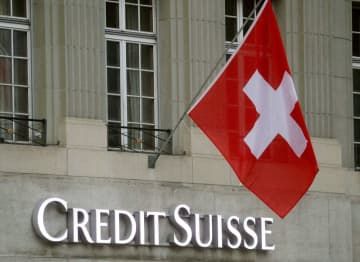 スイス金融大手クレディ・スイスのロゴとスイス国旗＝2022年11月、ベルン（ロイター＝共同）