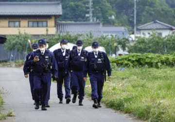 男が立てこもった現場の住宅付近で警戒を続ける警察官＝26日午前5時38分、長野県中野市