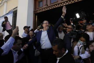 20日、グアテマラ市で大統領選の投票を終えたベルナルド・アレバロ元外務次官（中央）（AP＝共同）