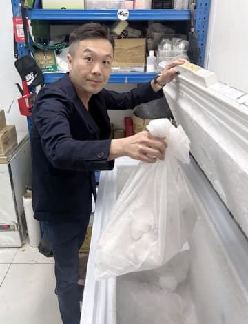 日本産の冷凍マグロを手にする高俊傑氏＝17日、香港（共同）