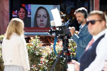 21日、裁判所の外の大型スクリーンに映し出されたレットビー被告の写真と報道関係者ら＝英中部マンチェスター（ロイター＝共同）