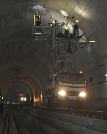 北陸新幹線の第2福井トンネルで、内壁のコンクリートに浮きがないかハンマーでたたいてチェックする鉄道・運輸機構の作業員ら＝22日午前、福井県鯖江市