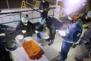 海水と混ぜた処理水を確認する東電社員ら＝22日、東京電力福島第1原発（東京電力提供）