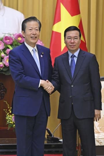 ベトナム・ハノイでボー・バン・トゥオン国家主席（右）と握手する公明党の山口代表＝23日（共同）