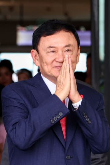 22日、タイ・バンコクの空港に帰国したタクシン元首相（ロイター＝共同）