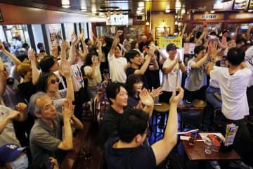 慶応高が107年ぶりの優勝を決め、喜ぶ人たち＝23日午後、横浜市