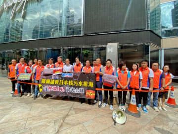 香港の日本総領事館が入るビルの前で、抗議活動を行った親中派政党「民主建港協進連盟」のメンバーら＝23日（共同）