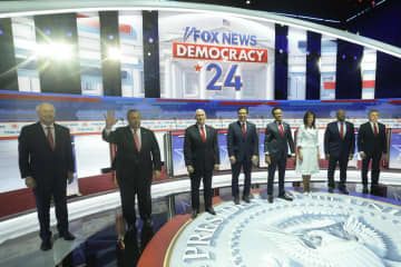 23日、米ウィスコンシン州ミルウォーキーで大統領選の共和党候補者討論会に臨む8人の候補者（AP＝共同）