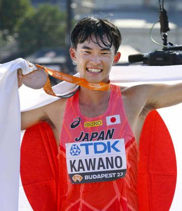 陸上の世界選手権男子35キロ競歩で銅メダルを獲得し、日の丸を掲げる川野将虎。今大会の日本勢のメダル第1号となった＝24日、ブダペスト（共同）
